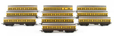 several yellow and black train cars are lined up on a white surface