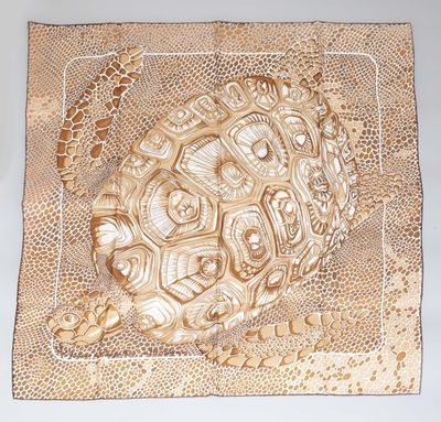 a close up of a gold plate with a turtle on it
