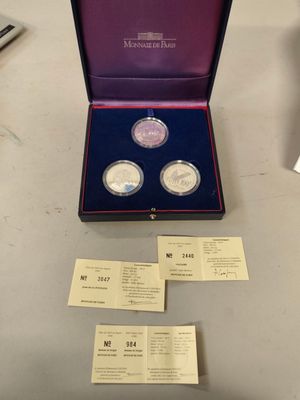 two silver coins are in a purple box on a table