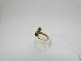 an image of a gold ring with a red stone on it