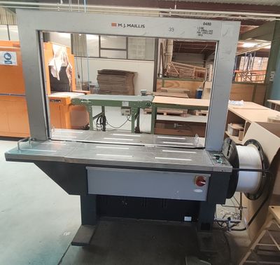 une machine qui se trouve dans une pièce où sont empilées de nombreuses boîtes