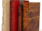 plusieurs vieux livres sont empilés sur une surface blanche