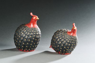 deux oiseaux noirs et rouges, assis l'un à côté de l'autre sur une table
