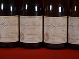 several bottles of wine are lined up on a red table