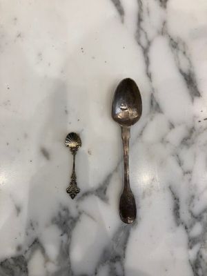 two spoons and a spoon rest on a marble table