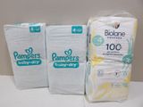 trois paquets de couches Pampers posés sur un plan de travail