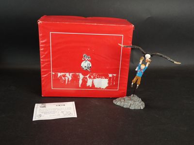 une figurine représentant un homme tenant une raquette de tennis à côté d'une boîte rouge
