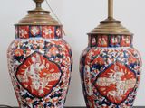 pair of asian vases on stand with lamps on top of them