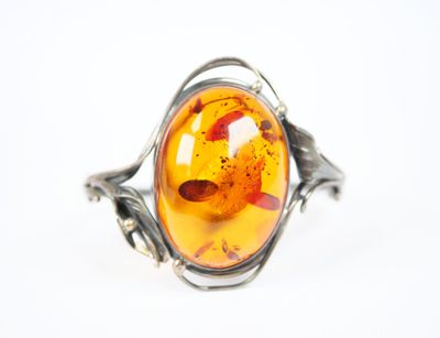 une image représentant une bague en argent ornée d'une grosse pierre d'ambre au centre