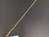 a close up of a gold necklace with a tag on it