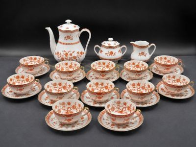 many cups and saucers and a teapot on the table