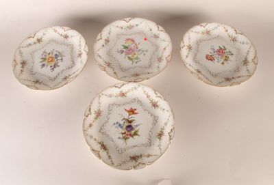 quatre assiettes ornées de motifs floraux sont disposées sur une surface blanche