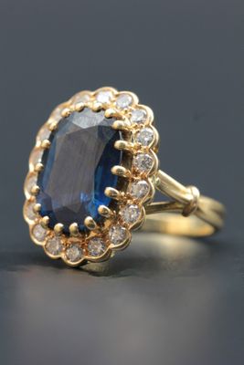 un gros plan d'une bague en saphir bleu et diamants