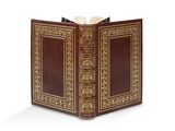 un vieux livre avec une couverture dorée sur fond blanc