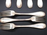 five forks and five spoons on a black surface