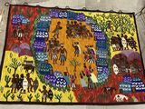 un tapis coloré posé par terre, sur lequel sont représentés des personnes et des animaux
