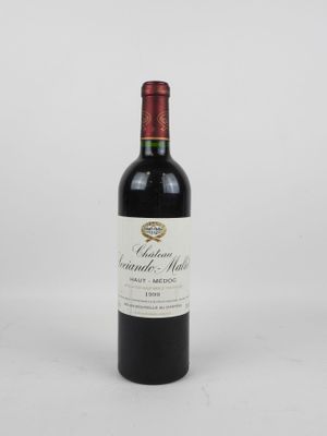 une bouteille de vin rouge posée sur une table blanche
