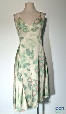 une robe posée sur un présentoir à mannequin sur lequel est posée une robe