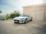 une voiture de sport blanche garée devant un garage