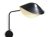 a black and white lamp on a wall next to a white wall