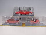 three red toy cars in clear boxes on top of a table