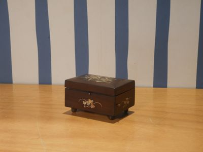 une petite boîte en bois posée sur un plancher en bois
