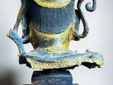 a statue of a vase on a stand on a white surface