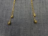 un gros plan sur une paire de boucles d'oreilles en or posées sur une table