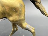 bronze statue of a running horse on a black surface
