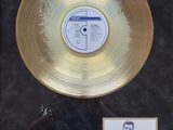 an image of a gold record with a picture of a man in a suit