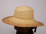 chapeau de paille beige sur une tête de mannequin, sur fond blanc