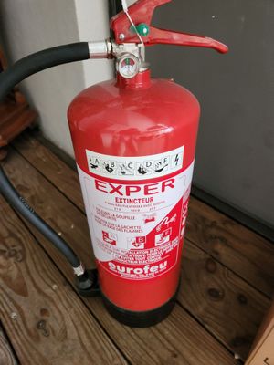 un extincteur posé sur une terrasse en bois