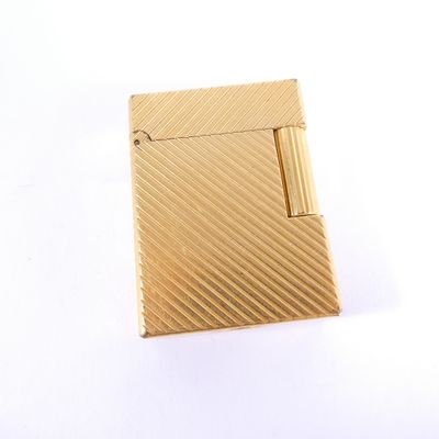 an image of a gold cigarette case sitting on a white surface