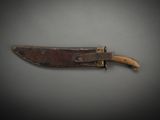 an old knife with a wooden handle sitting on top of a table