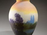 a vase with a painting on it sitting on a table