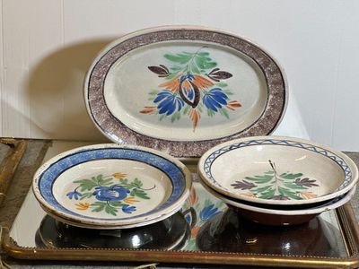 trois assiettes et un bol posés sur un plateau, lui-même posé sur une table