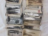 une pile de vieilles photos posée sur un lit, à côté d'un livre