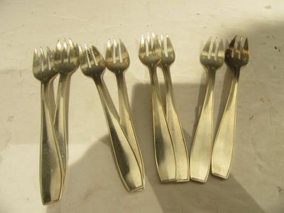 quatre fourchettes et cuillères en argent posées sur une table