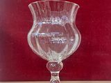 a glass vase sitting on a table with a red wall in the background