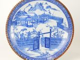 a blue and white plate with a mountain scene on it