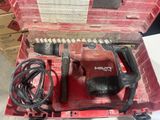 a red box with a drill and other tools inside of it