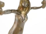an image of a bronze statue of a woman holding a lamp