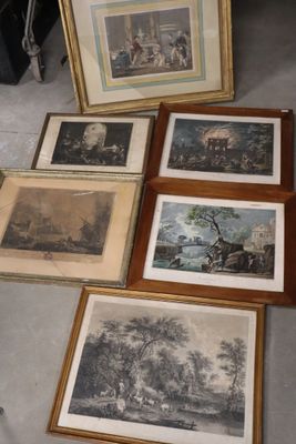 many framed pictures on the floor of a room