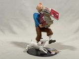 figurine of a man with a stack of books and a dog