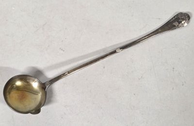 a silver spoon with a spoon handle on a white surface