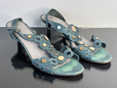 pair of women ' s shoes on a black surface with a white wall in the background