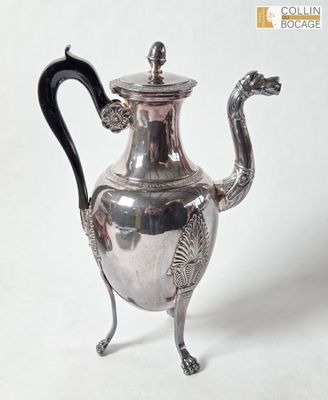 une théière en argent avec une anse en forme de dragon, posée sur un socle