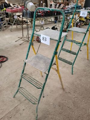 many chairs and ladders in a room with a lot of stuff on the floor