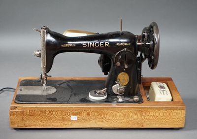 une machine à coudre noire et blanche posée sur un support en bois