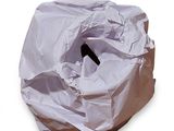 un sac blanc troué posé sur une surface blanche